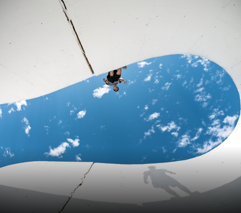 Skater reflecting in curved sky shape
